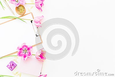 Beauty blog concept. Freelancer or blogger workspace with clipboard, notebook, pink tulips and accessories on white background. Fl Stock Photo