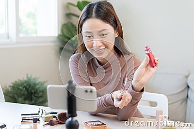 Beauty blogger, asian young woman, girl vlogger makeup face, showing, reviews cosmetics products while recording video, tutorial Stock Photo
