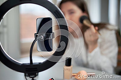 beauty blogging, technology and people concept portrait of a happy smiling girl blogger with ring light and smartphone applying Stock Photo