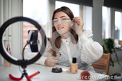 beauty blogging, technology and people concept portrait of a happy smiling girl blogger with ring light and smartphone applying Stock Photo