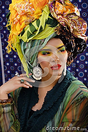 Beauty bright woman with creative make up, many shawls on head like cubian, ethno look closeup Stock Photo