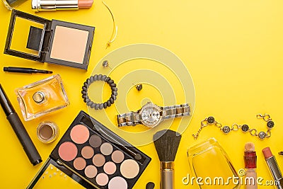 Beauty concept in a blog. Professional female make-up accessories, watch, bracelet, lipstick, powder, on a yellow background. Stock Photo