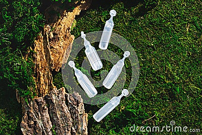 Beauty cosmetic ampoule, bottles on green forest landscape flat lay. Natural organic still life Stock Photo