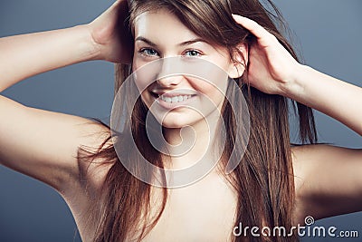 Beauty, face and smile portrait of a woman in studio with hands in hair, makeup and cosmetics. Headshot of a happy young Stock Photo