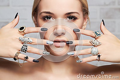 Beauty face.woman`s hands with jewelry rings Stock Photo