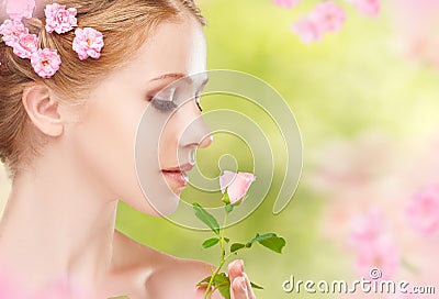 Beauty face of young beautiful woman with pink flowers in her ha Stock Photo