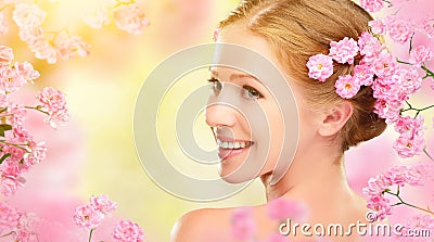 Beauty face of young beautiful woman with pink flowers in her ha Stock Photo