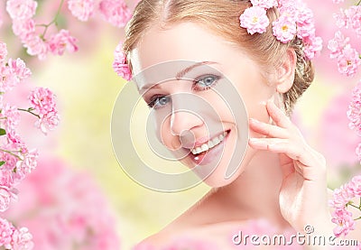 Beauty face of young happy beautiful woman with pink flowers in Stock Photo