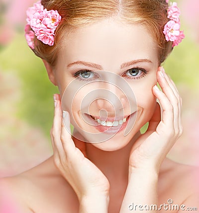 Beauty face of young happy beautiful woman with pink flowers in Stock Photo