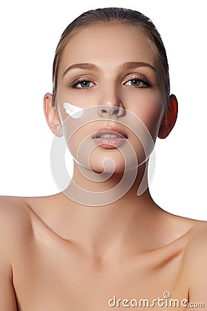 Beauty face of young woman. Beauty face of young woman with cosmetic cream on a cheek. Skin care concept. Closeup portrait Stock Photo