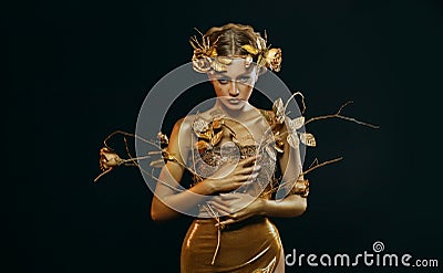 Beauty fantasy woman, face in gold paint. Golden shiny skin. Fashion model girl, image goddess. Glamorous crown, wreath Stock Photo