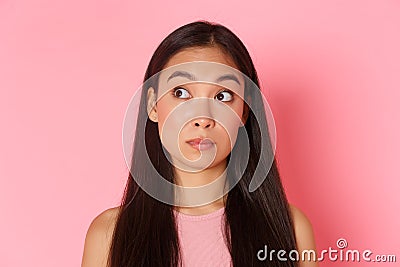 Beauty, fashion and lifestyle concept. Close-up of indecisive, pretty asian girl looking confused upper left corner Stock Photo