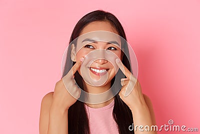 Beauty, fashion and lifestyle concept. Close-up of silly and cute, adorable asian girl poking her cheeks and smiling Stock Photo