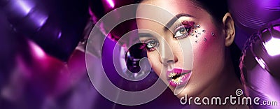 Beauty fashion model girl creative art makeup with gems. Woman face over purple, pink and violet air balloons Stock Photo