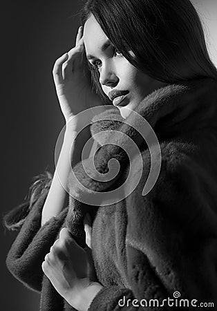 Beauty Fashion Model Girl in Mink Fur Coat black and white portrait. Beautiful Woman in Luxury Brown Fur Jacket posing in studio Stock Photo