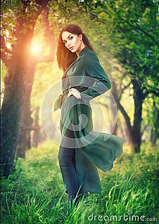 Beauty fashion model girl posing over blooming trees, enjoying nature in spring apple orchard Stock Photo