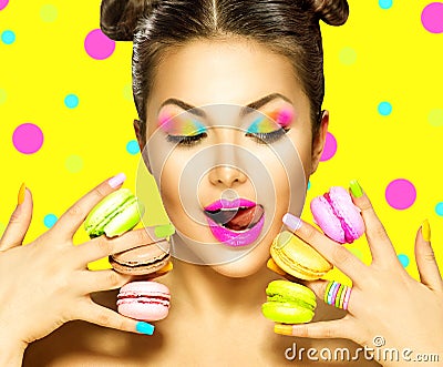 Beauty fashion model girl taking colorful macaroons Stock Photo