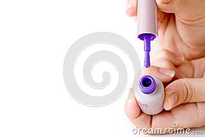 Beauty, fashion and Nail art concept. Manicure in nails spa salon -woman hands close-up with bottle and brush of purple gel nail p Stock Photo