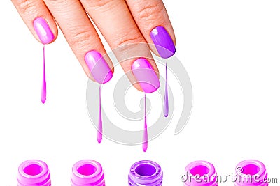 Beauty, fashion and Nail art concept. Woman hand close-up with five bottles of pink and purple gel nail polish and drops from fing Stock Photo