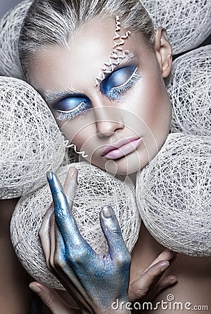 Beauty fashion portrait of beautiful woman with creative make-up White balls around the head model. makeover in blue and white Stock Photo