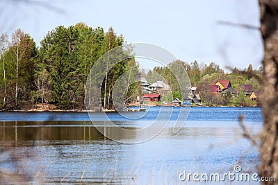 Beauty of forest lake with lakeside village with timber houses, calm water Stock Photo