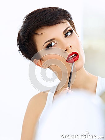 Beauty Girl with Makeup Brush. Natural Make-up for Brunette Woman with Red Lips Stock Photo