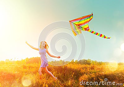 Beauty girl in short dress running with flying colorful kite Stock Photo