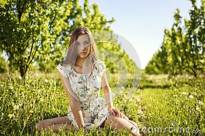 Beauty girl is sitting on the grass. Stock Photo
