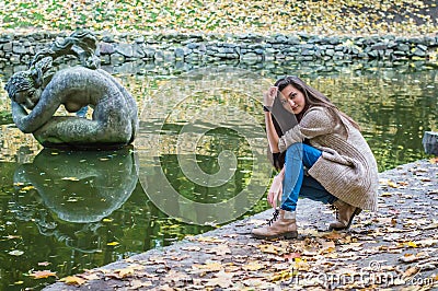 Beauty girl sitting near the pond Stock Photo