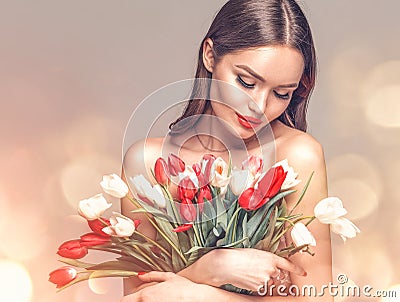 Beauty glamour girl with Spring tulips Flower bouquet. Beautiful young woman with a bunch of colorful Tulip flowers Stock Photo