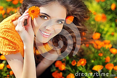 Beauty happy Romantic woman Outdoors. Beautiful Teenage girl embracing in golden marigold flowers Stock Photo