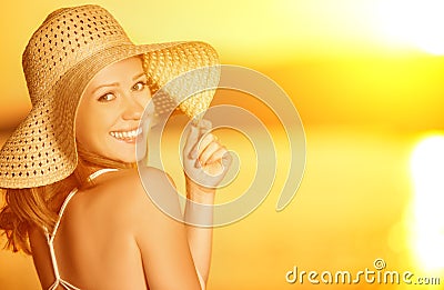 Beauty happy smiling woman in hat at sea at sunset on beach Stock Photo