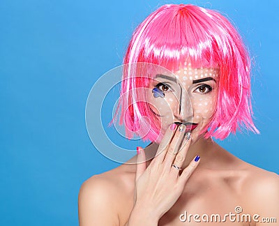 Beauty head shot. Cute Young woman with creative pop art make up and pink wig looking at the camera on blue background Stock Photo