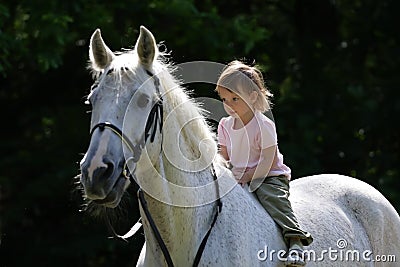 Beauty intent girl riding bareback by gray horse Stock Photo