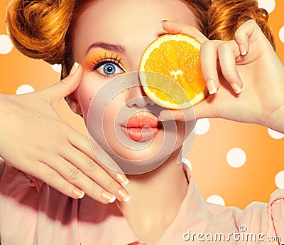 Beauty joyful teenage girl takes juicy oranges. Teen model girl with freckles, funny red hairstyle, yellow makeup and nails Stock Photo