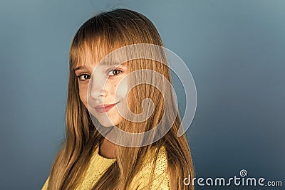 Beauty or kid fashion with cosmetics and healthy hair. Stylish girl with pretty face. Little girl with long hair Stock Photo