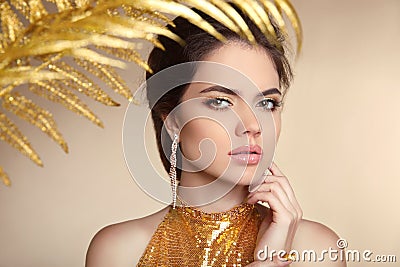 Beauty make-up. Beautiful girl model. Golden luxury Jewelry.Manicured nail. Fashion art photo of young woman isolated on beige ba Stock Photo