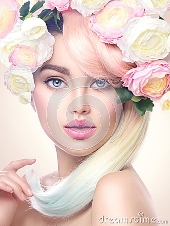 Beauty model girl with colorful flowers wreath and colorful hair. Flowers hairstyle Stock Photo