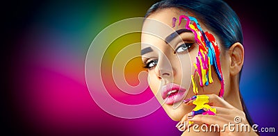 Beauty model girl with colorful paint on her face. Beautiful woman with flowing liquid paint Stock Photo