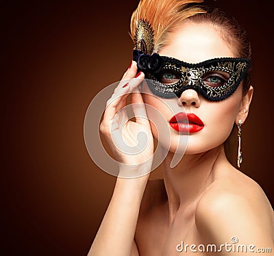 Beauty model woman wearing venetian masquerade carnival mask at party isolated on black background. Christmas and New Stock Photo