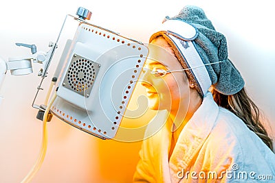 Beauty spa patient undergoing LED Photomodulation for a light-based facial, as an anti-aging treatment, and for sunburn healing Stock Photo