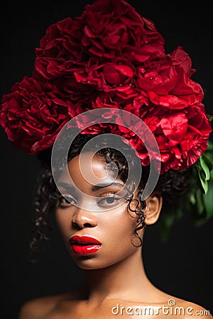 Beauty portrait of a young pretty girl with red flowers on her head. Stock Photo