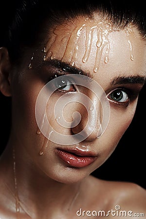 Beauty Portrait of Young Woman with Strobing Makeup Liquid on Fa Stock Photo