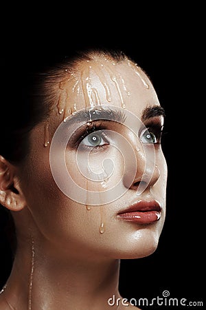 Beauty Portrait of Young Woman with Strobing Makeup Liquid on Fa Stock Photo