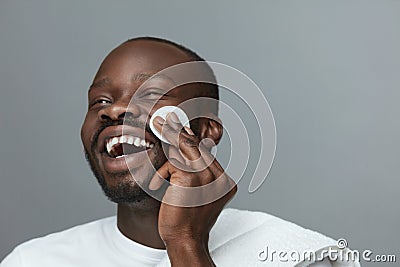 Beauty Routine. Face Cleaning Skincare For Man. Male African Model Cleans Facial Skin. Stock Photo