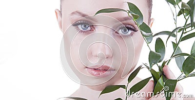 Beauty shoot. European, young, blue-eyed woman posing with fresh, green leaf. Stock Photo