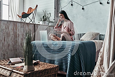 Beauty surfing the net. Attractive young woman using computer an Stock Photo