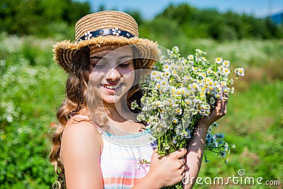 Beauty is taking time to get pampered. Happy girl smile with chamomile bunch. Beauty look of small kid. Natural skincare Stock Photo