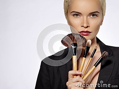 Beauty Treatment. Girl with Makeup Brushes. Fashion Make-up for Woman. Makeover. Make-up Artist Applying Visage Stock Photo