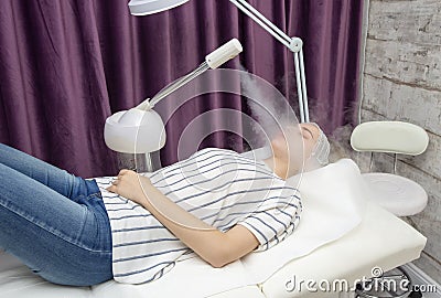 Beauty treatment of young female face, ozone facial steamer Stock Photo